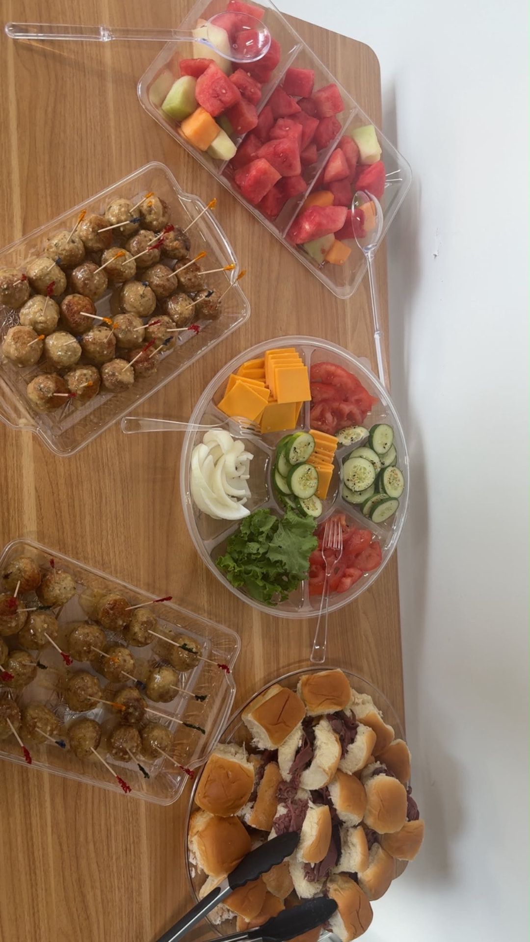Eve's Garden Deli catering spread with sliders meatballs fruit cups and veggie trays
